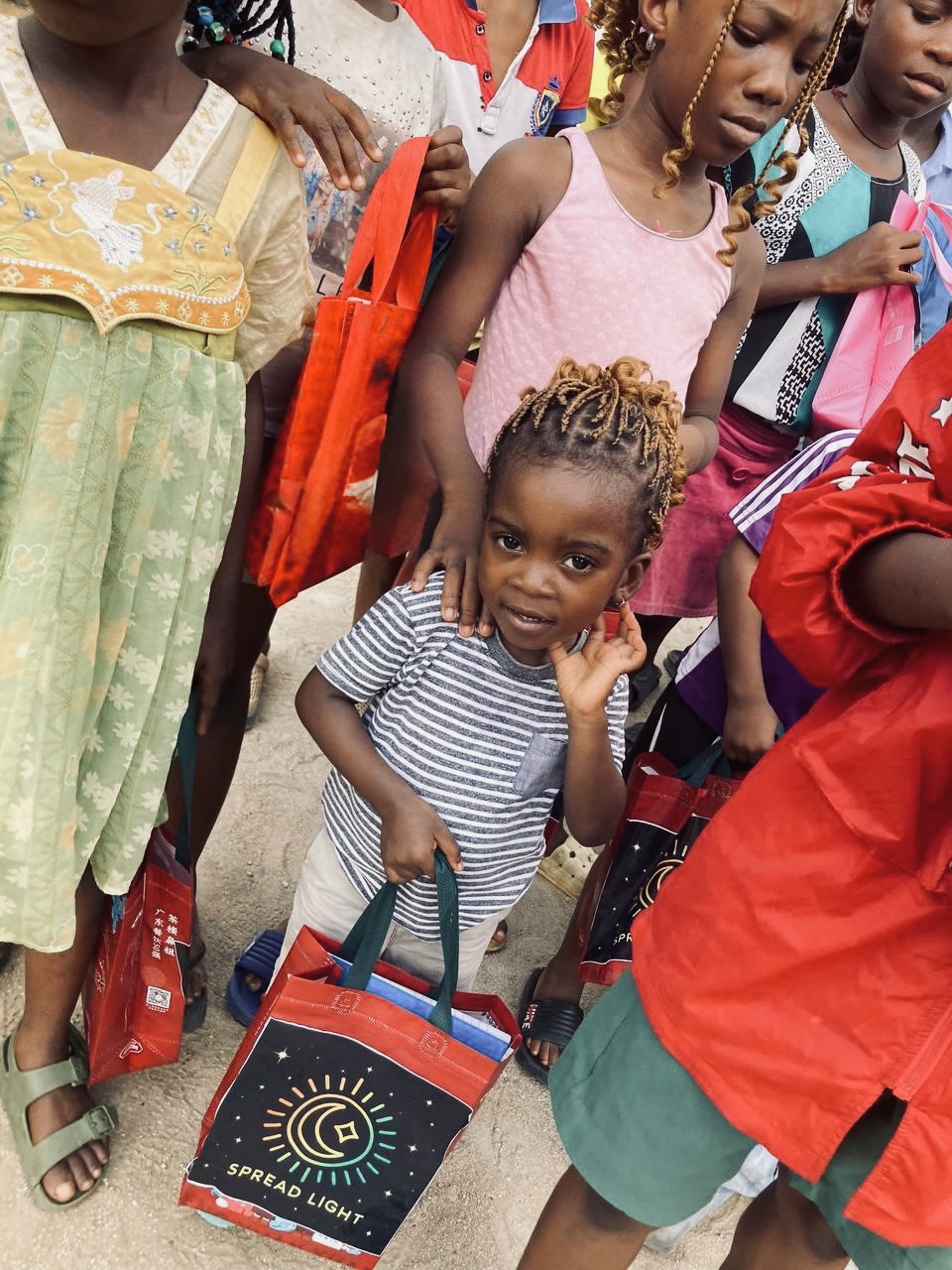 Young child holding a Spread Light branded gift bag